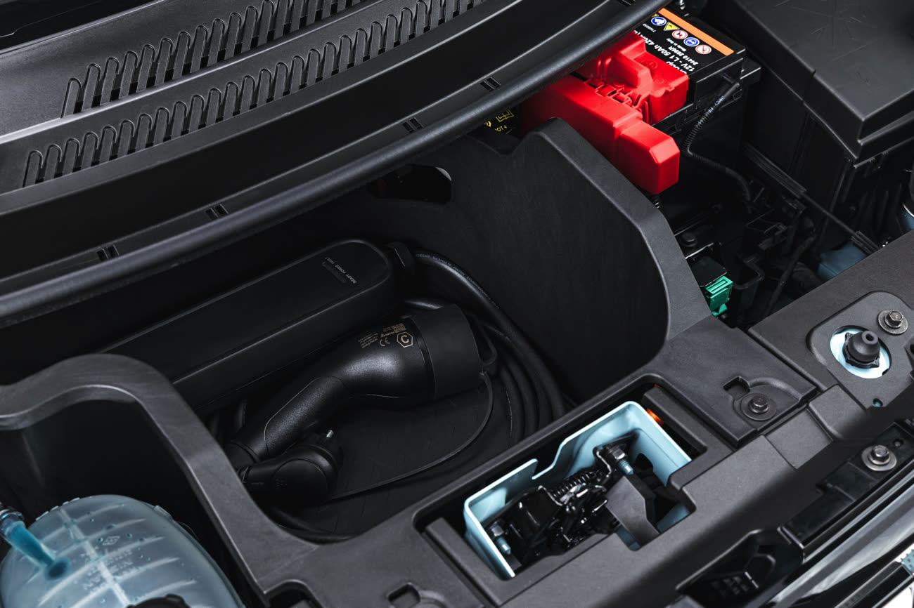 Le capot avant s’ouvre et révèle un tout petit coffre, suffisant pour un câble, éventuellement deux s’ils sont courts, mais c’est une option. Image Dacia.